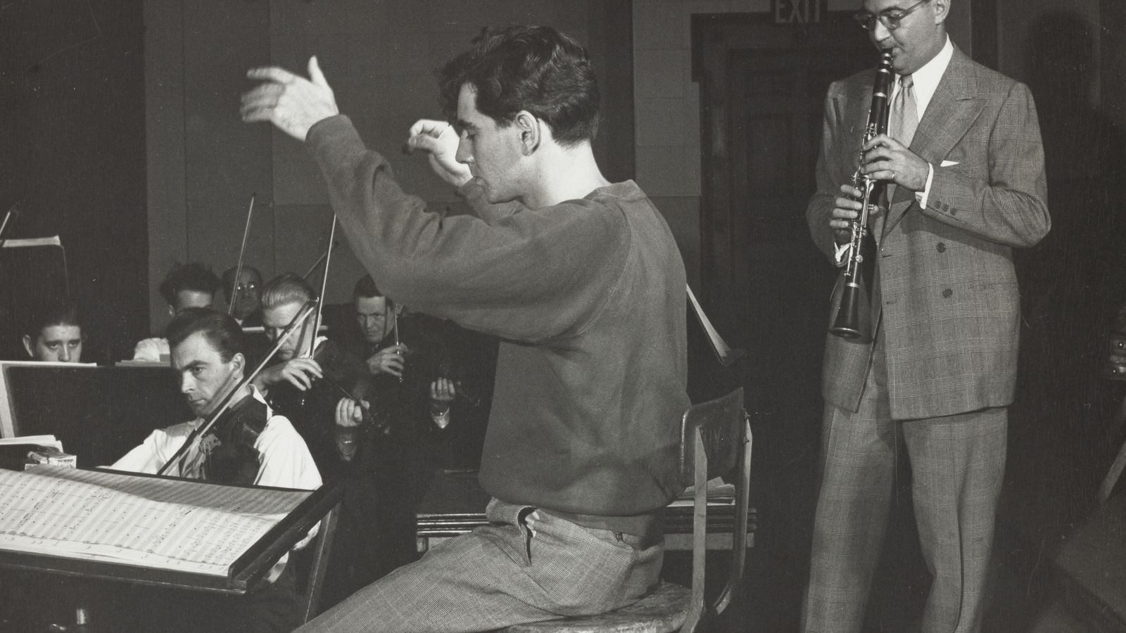 Leonard Bernstein conducting as Benny Goodman rehearses with an orchestra
